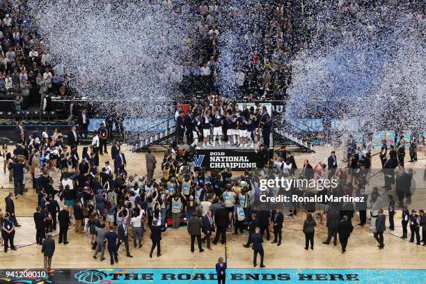 Jalen Brunson of the Villanova Wildcats raises the trophy and celebrates with his teammates after defeating the Michigan Wolverines during the 2018...