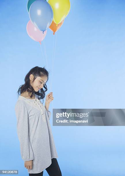 young woman holding balloons - woman smiling facing down stock pictures, royalty-free photos & images