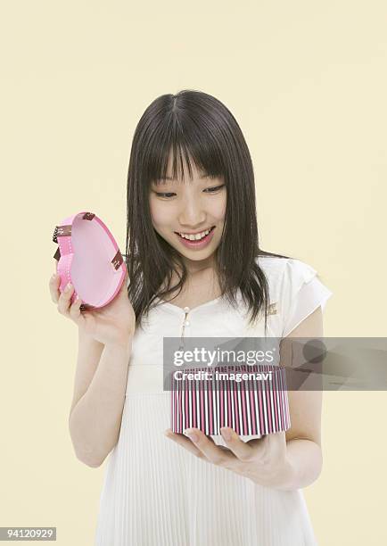 young woman opening present - woman smiling facing down stock pictures, royalty-free photos & images