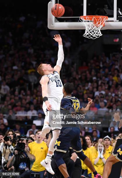 Donte DiVincenzo of the Villanova Wildcats attempts a shot against Muhammad-Ali Abdur-Rahkman of the Michigan Wolverines during the first half in the...