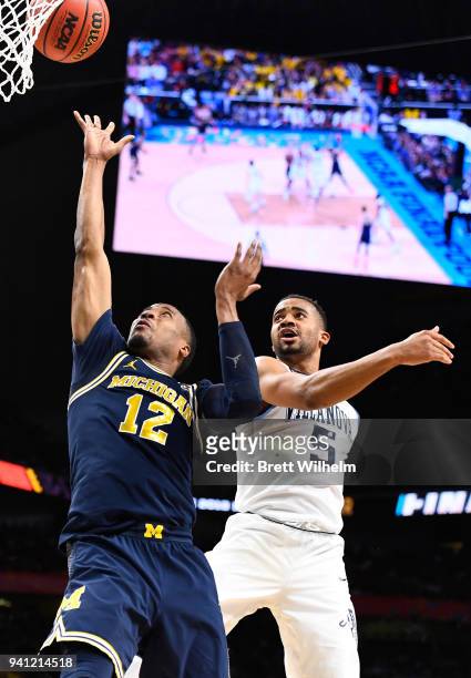 Muhammad-Ali Abdur-Rahkman of the Michigan Wolverines shoots the ball against Phil Booth of the Villanova Wildcats during the second half in the 2018...