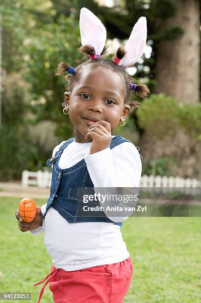 young girl with bunny ears holding easter egg, south africa - easter bunny ears ストックフォトと画像