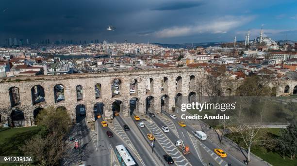 An aerial view of Valens Aqueduct while traffic flows at Ataturk Boulevard with Suleymaniye Mosque in the background in Fatih district of Istanbul,...