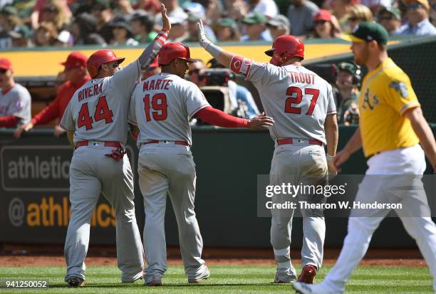 Rene Rivera and Jefry Marte of the Los Angeles Angels of Anaheim is congratulated by teammate Mike Trout after they both scored on an rbi double from...