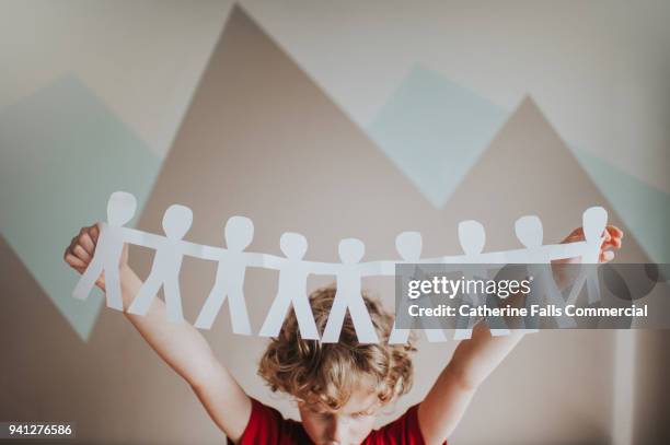 boy holding a paper chain - paper man stock pictures, royalty-free photos & images