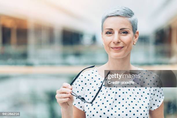 geschäftsfrau holding eyeglasses - nur erwachsene stock-fotos und bilder