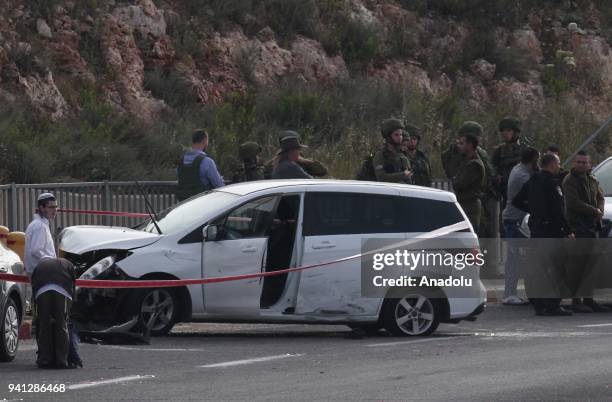 Israeli security forces investigate near the crashed car of a Palestinian man, shot dead by Israeli forces on suspicion of a terror attack, after his...