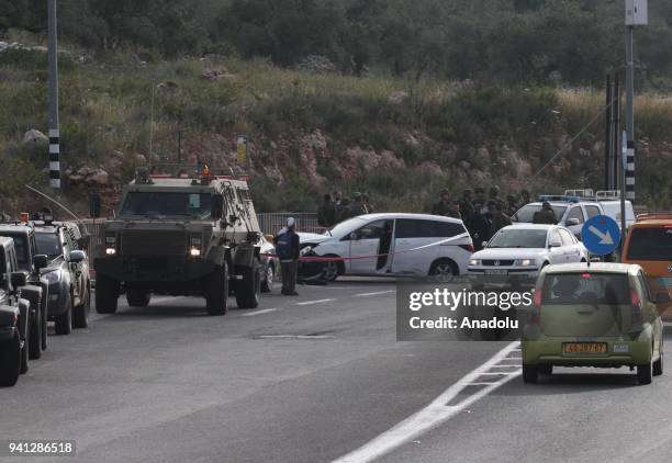 Israeli security forces investigate near the crashed car of a Palestinian man, shot dead by Israeli forces on suspicion of a terror attack, after his...