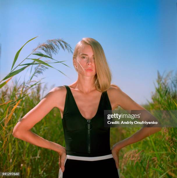 portrait of beautiful young woman in a tall grass - andriy onufriyenko stockfoto's en -beelden