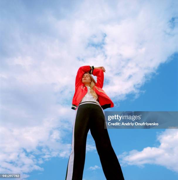 portrait of beautiful young woman over blue sky - high fashion stock-fotos und bilder