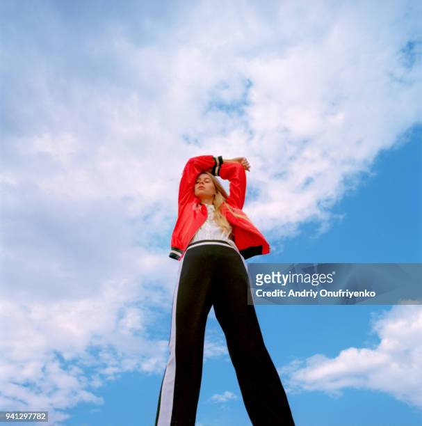 portrait of beautiful young woman over blue sky - a la moda fotografías e imágenes de stock