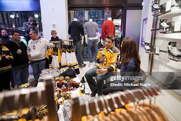 Milan Lucic, left wing for the Boston Bruins, is interviewed by NHL.com's Carrie Milbank during a question and answer session at the NHL Store on...