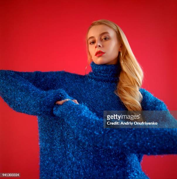 portrait of beautiful young woman on red background - maglione foto e immagini stock