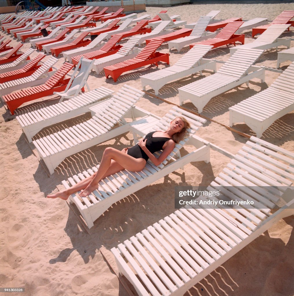 Portrait of beautiful young woman lying on a beach chaise