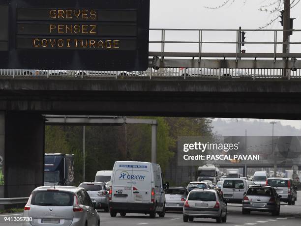 Vehicle drive past a sign reading "strike: think carpool" on a highway in Toulouse, southern France on April 3 at the start of three months of...