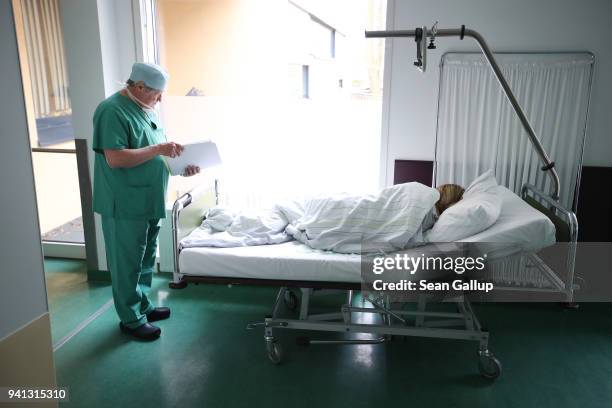 Doctor Janusz Rudzinski checks the documents of a young woman from Poland awaking from anesthesia after she underwent an abortion at the Krankenhaus...