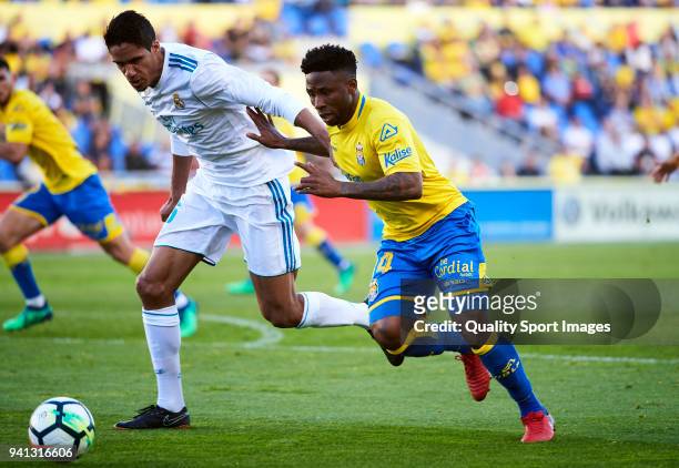 Raphael Varane of Real Madrid competes for the ball with Imoh Ezekiel of UD Las Palmas during the La Liga match between Las Palmas and Real Madrid at...
