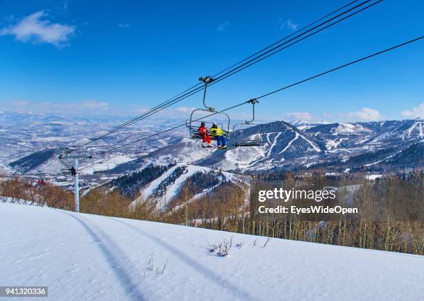 Skiers are sitting in a chair lift with panoramic view of the Wasatch Range in the Rocky Mountains on March 02, 2015 in Park City, Utah, United...