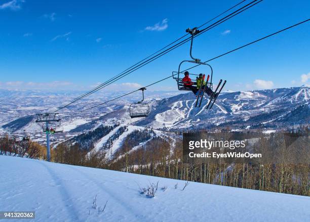 Skiers are sitting in a chair lift with panoramic view of the Wasatch Range in the Rocky Mountains on March 02, 2015 in Park City, Utah, United...
