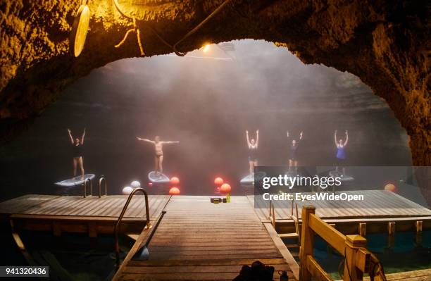 People with bathing suites are practicing Paddleboard Yoga in the Hot Water of the Homestead Crater on March 02, 2015 in Midway, Utah, United States.