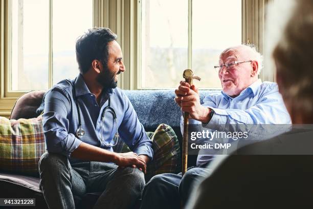 lächelnd arzt besuch senior mann zu hause - life advice stock-fotos und bilder
