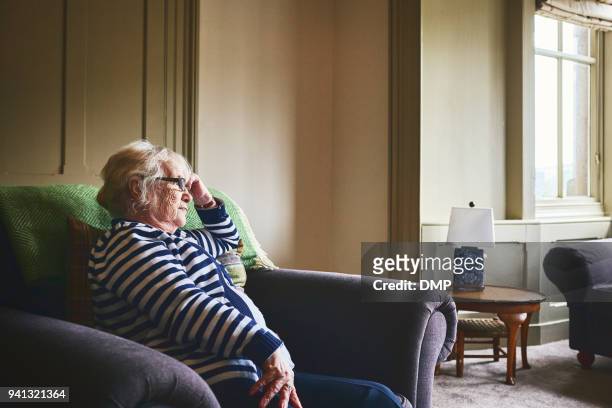 senior woman sitting alone at home - loneliness stock pictures, royalty-free photos & images