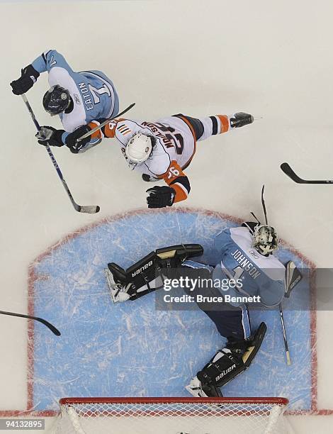 Brent Johnson of the Pittsburgh Penguins tends net against Matt Moulson and John Tavares of the New York Islanders at the Nassau Coliseum on November...