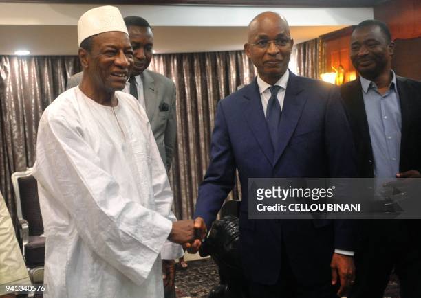 President Alpha Conde of Guinea shakes hands with Guinea opposition leader Cellou Dalein Diallo after their meeting at the presidential palace in...