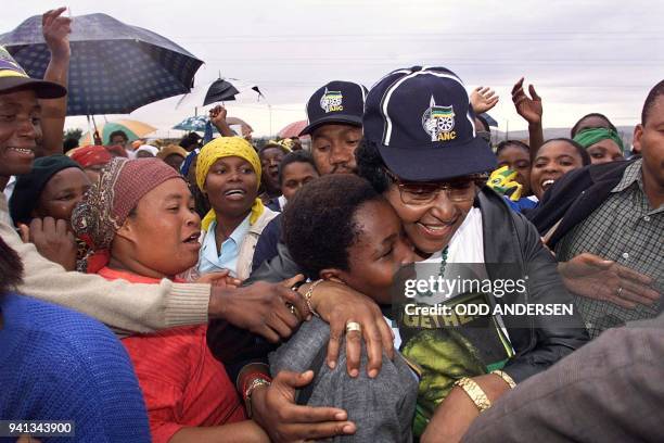 Crowd mobs Anti-apartheid campaigner Winnie Madikizela-Mandela of the African National Congress as she is hugged by a supporter, 21 April 1999 in the...