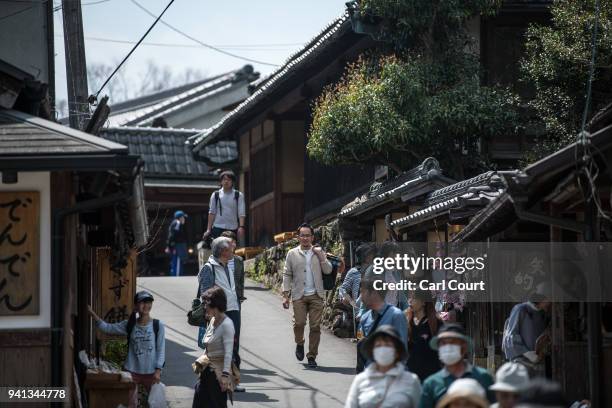 Visitors walk along a street on April 3, 2018 in Yoshino, Japan. The town of Yoshino in Nara Prefecture has become famous throughout Japan for the...