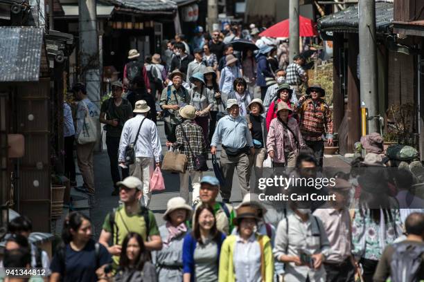Visitors walk walk along a busy street on April 3, 2018 in Yoshino, Japan. The town of Yoshino in Nara Prefecture has become famous throughout Japan...
