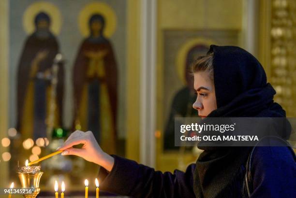 Woman lights a candle for victims on the one year anniversary of the Saint Petersburg metro terrorist attack on April 3, 2018 in Saint Petersburg....