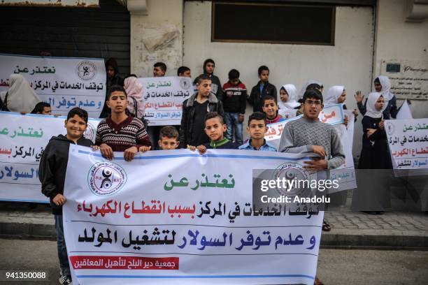 Palestinian disabled demonstrators hold placards during a protest against cutting the support services to centers for the handicapped people, by the...