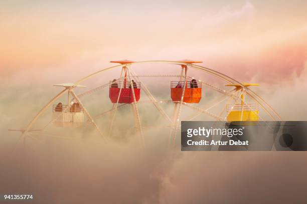 surreal picture of colorful ferris wheel emerging from the clouds. - tibidabo fotografías e imágenes de stock