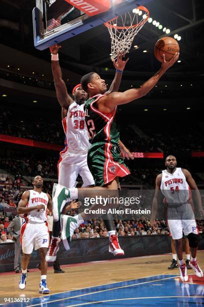 Charlie Bell of the Milwaukee Bucks goes to the basket under pressure against Kwame Brown of the Detroit Pistons during the game on December 4, 2009...