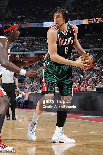 Andrew Bogut of the Milwaukee Bucks handles the ball against Kwame Brown of the Detroit Pistons during the game on December 4, 2009 at The Palace of...