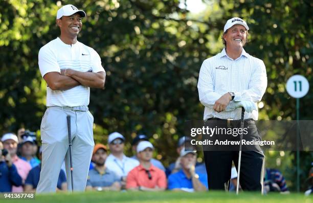 Tiger Woods and Phil Mickelson of the United States talk on the 11th hole during a practice round prior to the start of the 2018 Masters Tournament...