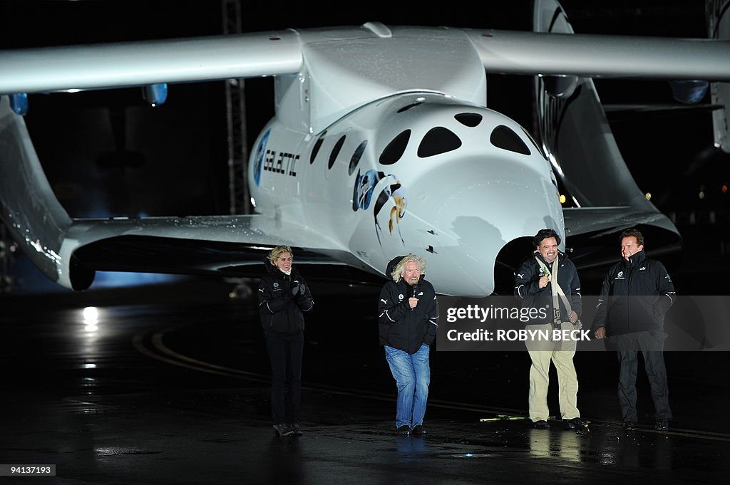 Sir Richard Branson (2L) reacts to the c