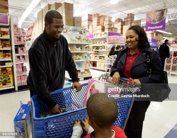 Chris Paul of the New Orleans Hornets visits with one of 100 local children who were provided with a shopping spree at Toys 'R' Us on December 7,...