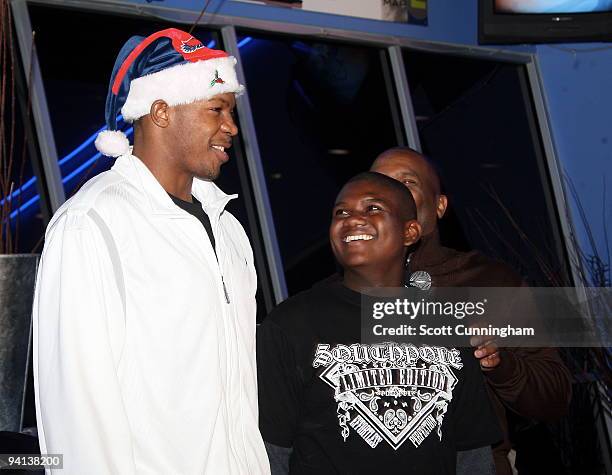 Joe Johnson of the Atlanta Hawks speaks to a youth at his annual Santa-Lanta Holiday Event at Andretti Karting & Games Center on December 7, 2009 in...