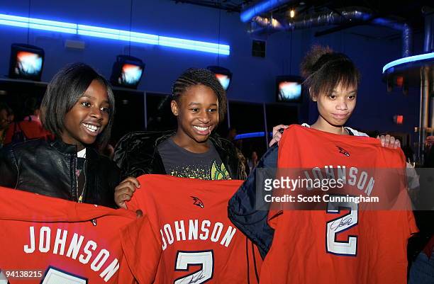 Youth in attendance show off their autographed shirts given away at Joe Johnson's annual Santa-Lanta Holiday Event at Andretti Karting & Games Center...