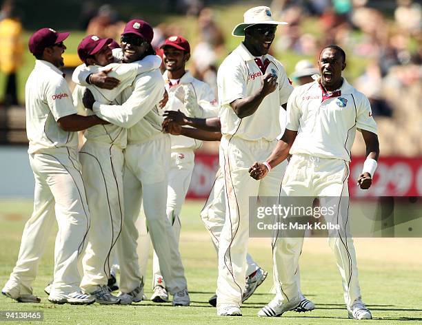 Ramnaresh Sarwan is embraced by Chris Gayle as Darren Sammy celebrates with Dwayne Bravo of the West Indies after he took the wicket of Marcus North...