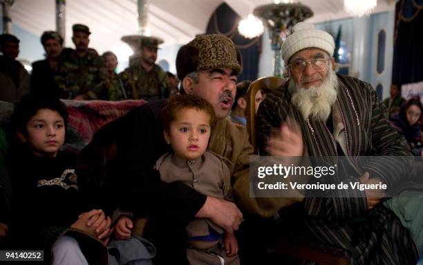 General Dostum attends a dombra concert at his palace in Sheberghan, Afghanistan. Closest to him are the two sons of one of his men who was killed...