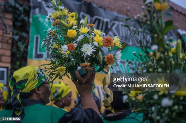 Members of the ANC Women's League bring flowers and sing to pay tribute to late South African anti-apartheid campaigner Winnie Madikizela-Mandela,...