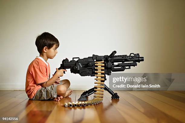 boy with toy machine gun - toy gun stock pictures, royalty-free photos & images