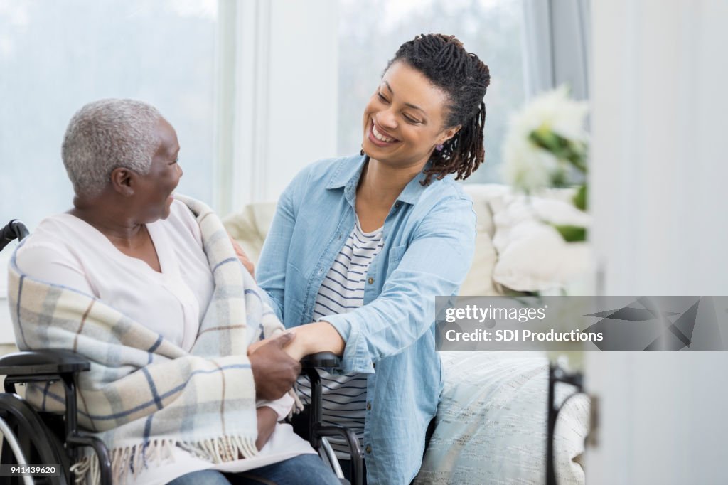 Mujer feliz ayuda a anciana madre