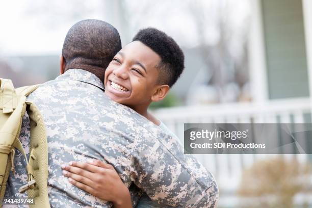 preteen boy reunites with military dad - returning soldier stock pictures, royalty-free photos & images