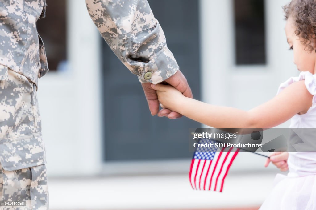 Soldado y su hija caminan de la mano