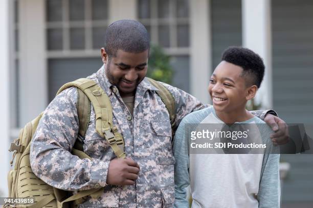 military father talks with son before leaving for assignment - military rucksack stock pictures, royalty-free photos & images