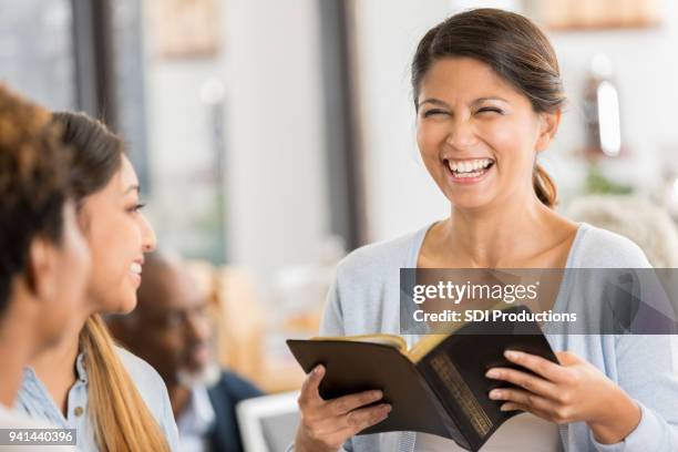 cheerful woman leads bible study - clero imagens e fotografias de stock